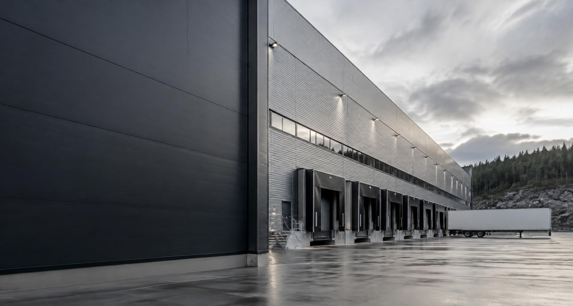Silver-clad logistics warehouse in a Nordic industrial landscape